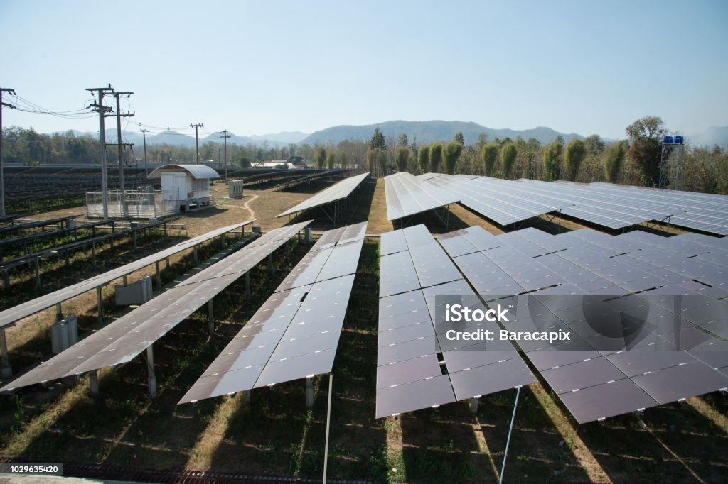 View of solar farm in sunlight with blue sky, dirty solar cell  array, green energy concept.