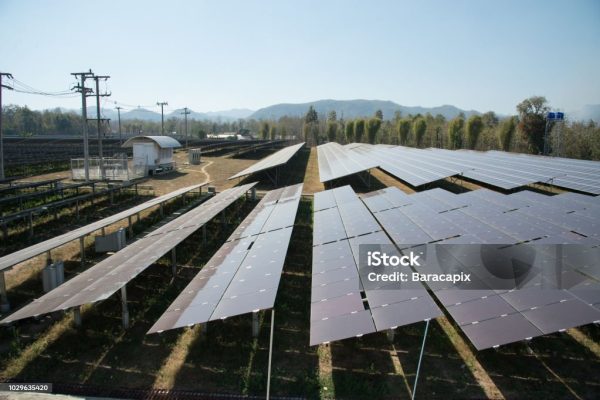 View of solar farm in sunlight with blue sky, dirty solar cell  array, green energy concept.
